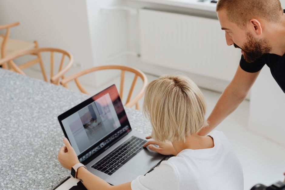 Two colleagues comparing software options on a laptop